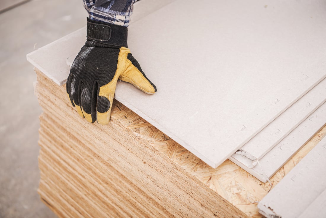 Worker Fixing Drywall and Plywood Materials